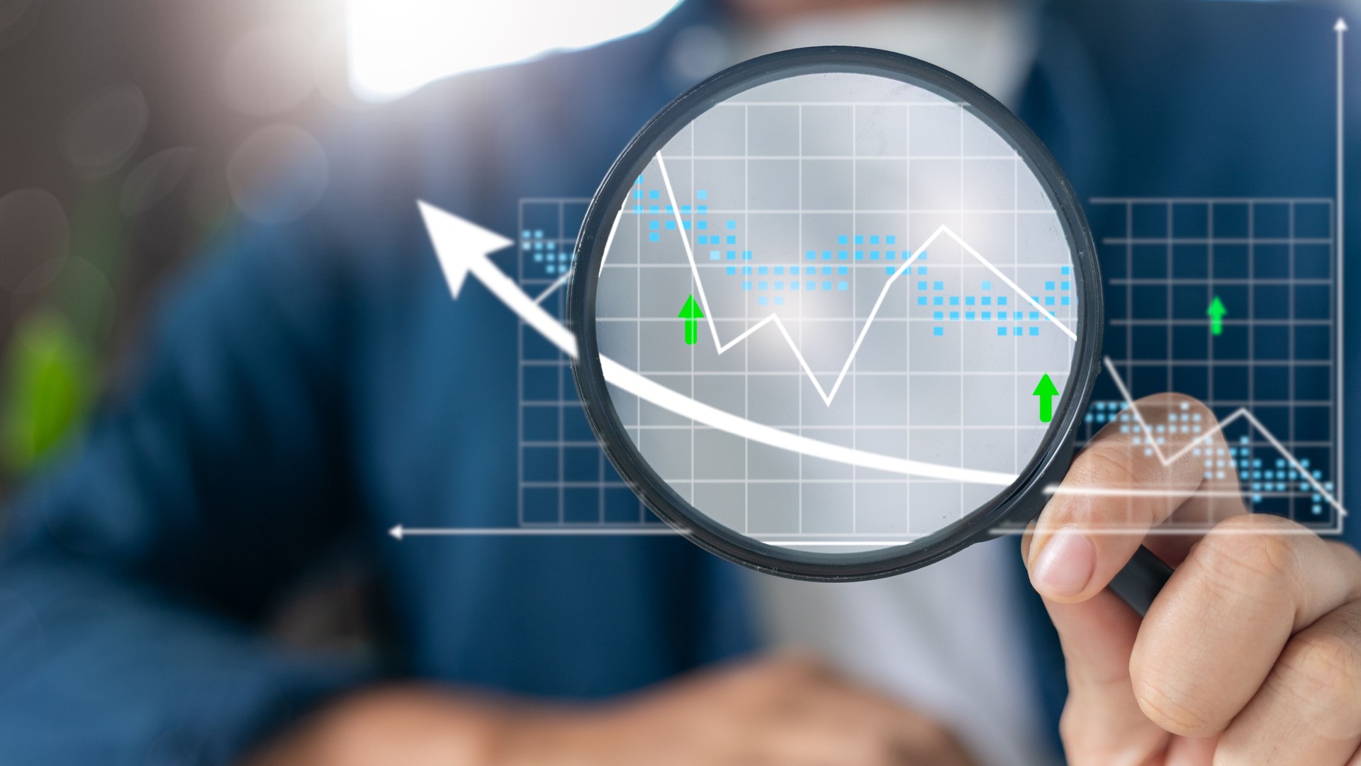 Hand holding magnifying glass analyzing financial graph, business data analysis, market trends, economic growth, and investment strategy concept.